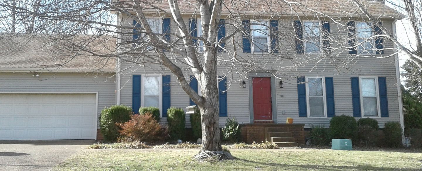 house with red door and dried tree outside jackson tn